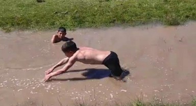 Çocuklar çamurlu suda doyasıya serinledi